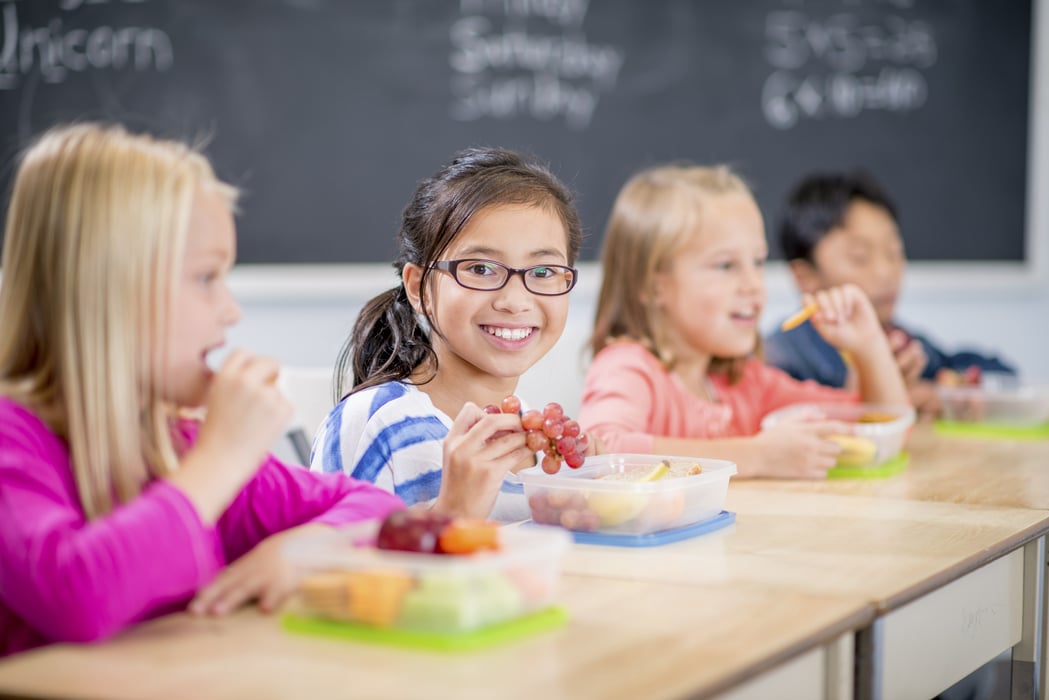 Children smiling and eating fruit