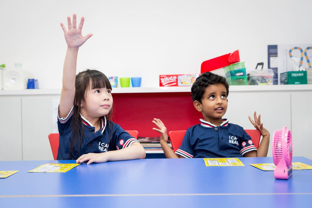 Two girls in I Can Read uniform engaging in class