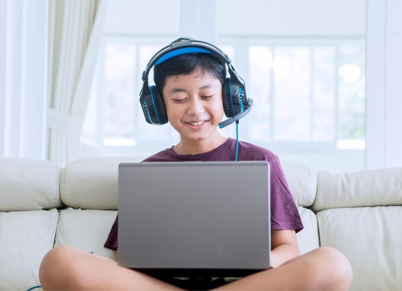 Boy in headsets engaged in online learning